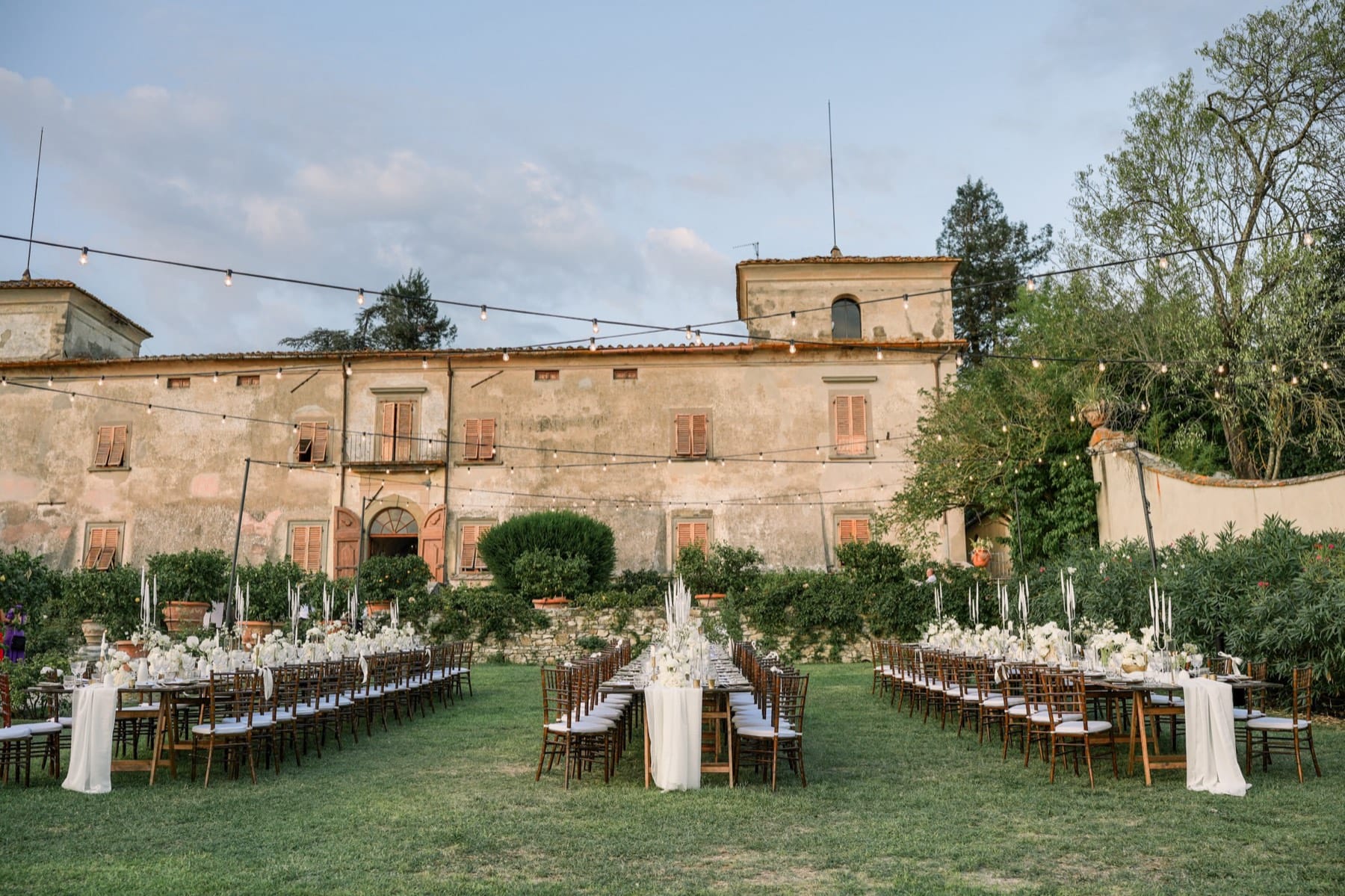 Long tables set in front of a historic villa